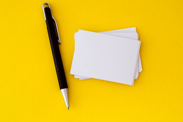 stacking of mockup empty white business card with elegance pen  on vibrant yellow background , a...