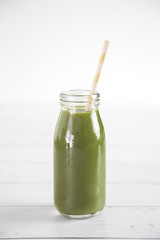 Green Fruit and Veggie  Smoothy on a White Wood Table