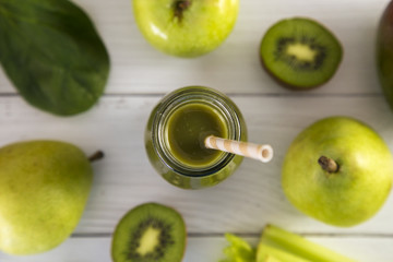 Green Fruit and Veggie  Smoothy on a White Wood Table