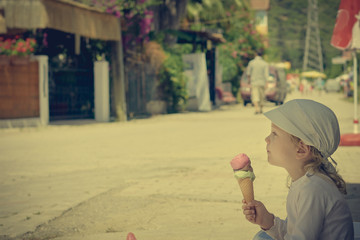 Cute boy with ice-cream sitting. image with warm vintage toning