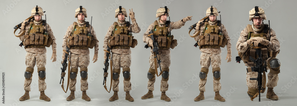 Wall mural Soldier in camouflage holding rifle