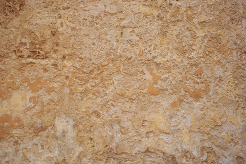 Weathered yellow painted wall background, partially faded