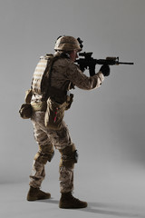 Soldier in camouflage holding rifle