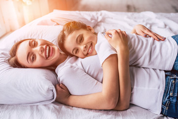 The attractive daughter and a mother laying on the bed