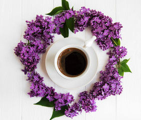 Obraz na płótnie Canvas Cup of coffee and lilac flowers