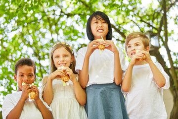 Multikulturelle Gruppe Kinder isst Baguette