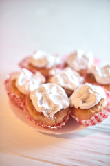 Cupcakes with white cream on a wooden background