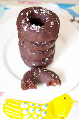 Raw vegan chocolate donuts with dates, walnuts, cocoa beans, almonds and coconut. Healthy food concept.