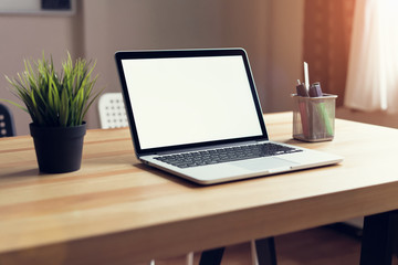 Fototapeta premium Laptop on table in the office room background, for graphics display montage. Take your screen to put on advertising.