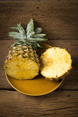 pineapple on dish half on old wood