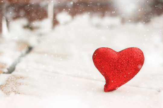 Red glitter heart in the winter snow