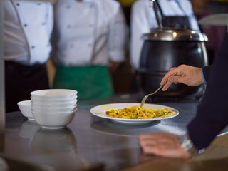 chefs in the kitchen presenting dish of tasty meal