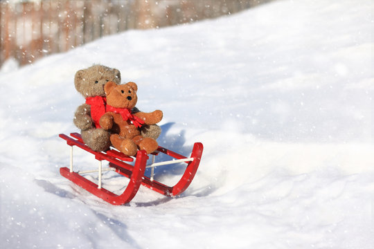 Teddy bears sledding in the winter snow