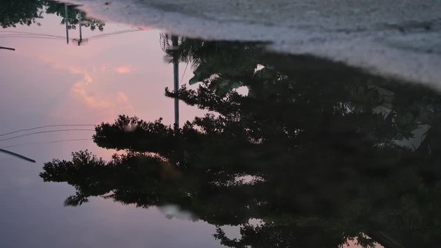 reflection twilight sunset sky in puddle water flooding on street