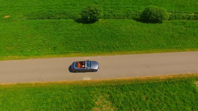
modern luxury convertible car driving on the country road on a sunny day - fun car driving -  aerial view - top view