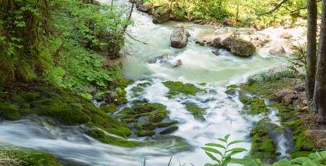 streams of clean water, Isichenko waterfall in Mezmay, Adygea, Caucasus surrounded by young green grass in the spring