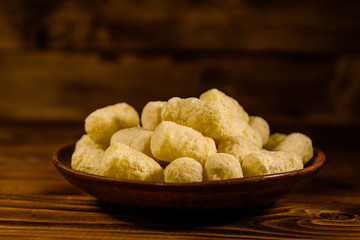Ceramic plate with corn sticks on wooden table
