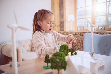 Ecological project. Smart nice girl standing at the table while working on the ecological project