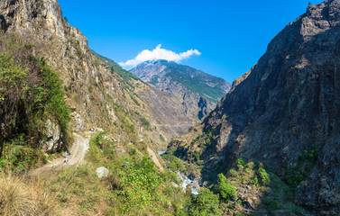 Naklejka premium Tourists on the mountain road on the track around Annapurna March 29, 2018 in Nepal.