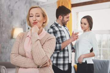Unpleasant neighbor. Sly elderly woman smiling while visiting her neighbors