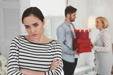 Negative emotions. Angry unhappy woman standing cross handed while thinking about her mother in law