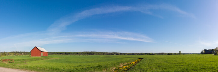 Fototapeta na wymiar Green field panorama with red barn