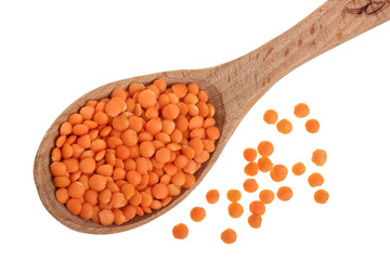 Heap of raw red lentils in wooden spoon isolated on white background