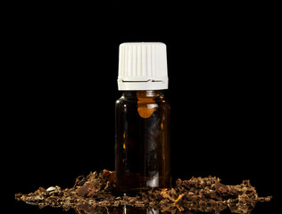 Bottle with aromatic liquid for vaping e-cigarette, near tobacco, isolated on black