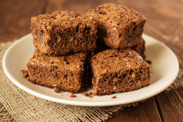 Dish with mouth-watering chocolate cakes on wooden table