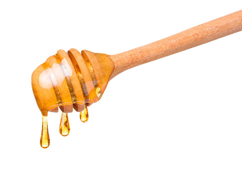 Honey drops dripping from wooden dipper spoon isolated on white background