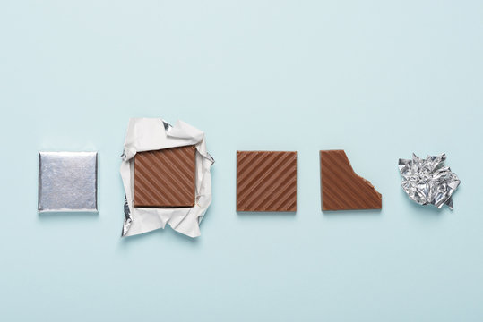 Chocolate bar cycle on blue pastel paper background concept