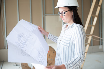 Architektin mit Bauzeichnungen auf einer Baustelle 
