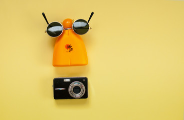 Sun protection cosmetics  and sunglasses and a set of accessories for summer vacationon on a yellow background , concept of health and beach rest
