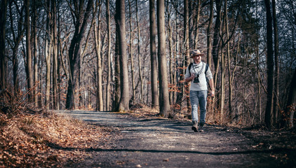Obraz premium Traveler man with vintage camera and backpack, hipster tourist in forest