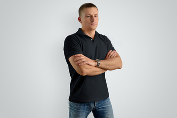 Mockup  black polo shirt on a strong man with arms crossed over his chest.