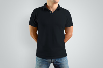 Mockup  black polo shirt on a strong guy. Isolated on a gray background.