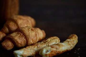 Puff pastries on dark wooden table, close-up, selective focus, shallow depth of field.