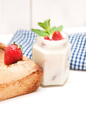 Biscuit and cream with strawberry on whity wooden background.
