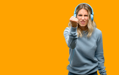 Young beautiful woman listening to music irritated and angry expressing negative emotion, annoyed with someone