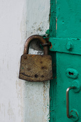 Old iron barn lock on a green door. Vertical image.