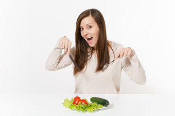 Vegan woman at table with leaves salad lettuce, vegetables on plate isolated on white background. Proper nutrition, vegetarian food, healthy lifestyle dieting concept. Advertising area with copy space