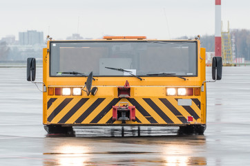 Aerodrome tow tractor is driving along the steering paths at the airport.
