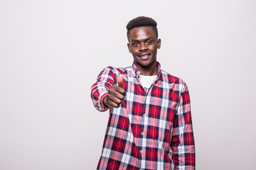 Portrait of young african-american man showing thumb up and smiling, over white