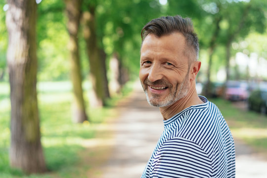 Cheerful mature man standing in park
