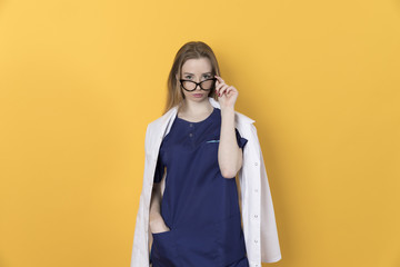 Doctor woman in black glasses on yellow background