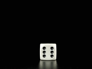 Game die isolated against black background, face with number six