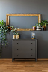 Golden frame above gray dresser