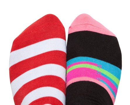 One pair of feet in different socks, isolated on white background