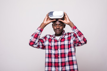 Young African American young man wearing vr virtual reality headset over white background.