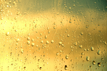 Rain drops on the glass at sunset. Sunset outside the window. Rain on the window